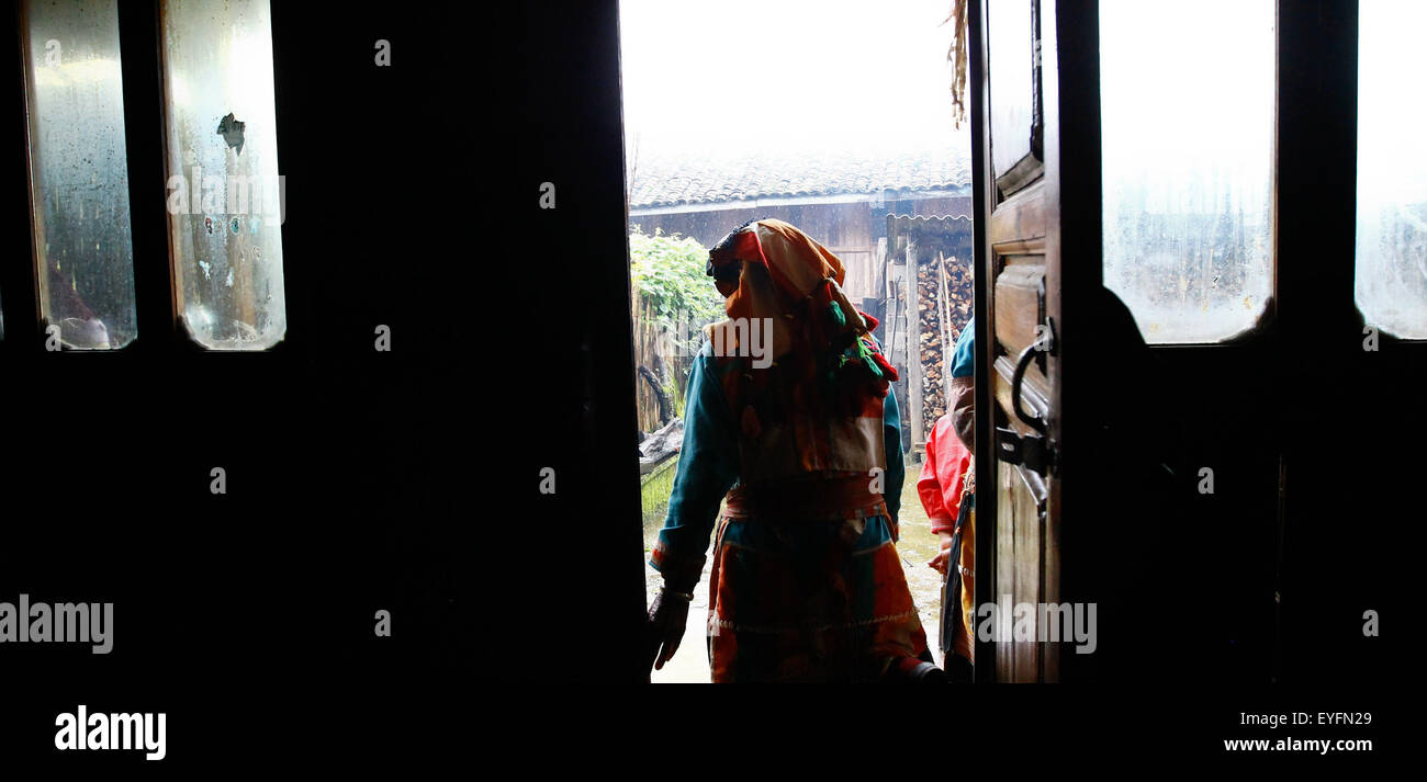 Beijing, China's Yunnan Province. 23rd July, 2015. A woman of Lisu ethnic group walks out of her house in Caijiazhai Village of Houqiao Township, Tengchong, southwest China's Yunnan Province, July 23, 2015. Houqiao Township is located in a gateway of the Stilwell Road linking southwest China's Yunnan and Myanmar, also known as the Burma Road, on which guns, ammunition, food and other badly needed materials were carried by U.S. trucks to China to fight against the Japanese troops. © Xue Dongmei/Xinhua/Alamy Live News Stock Photo