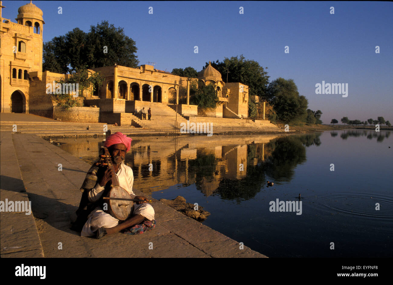Musician playing traditional stringed instrument, Gadi Sagar Tank; Jaisalmer, India Stock Photo