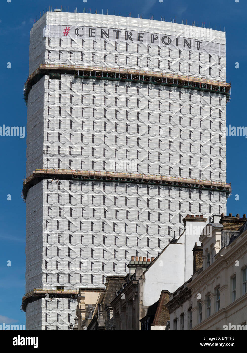 Centre Point, London, covered in screening with window design to hide scaffolding. With New Oxford St. buildings in foreground. Stock Photo