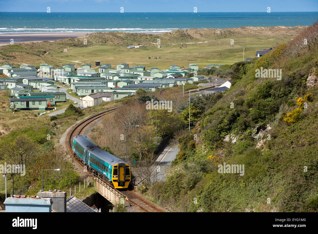 UK, Wales, Gwynedd, Aberdovey, Cambrian Coast line train approaching village past Golf Course and dunes Stock Photo