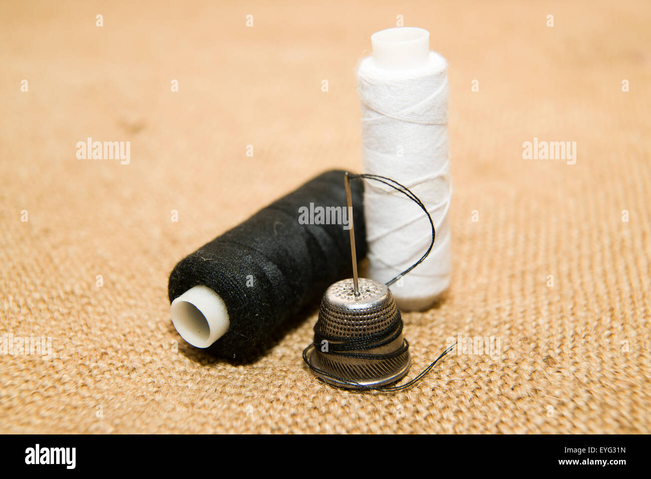 Sewing Needle, thimble and thread spool on the old cloth Stock Photo Alamy