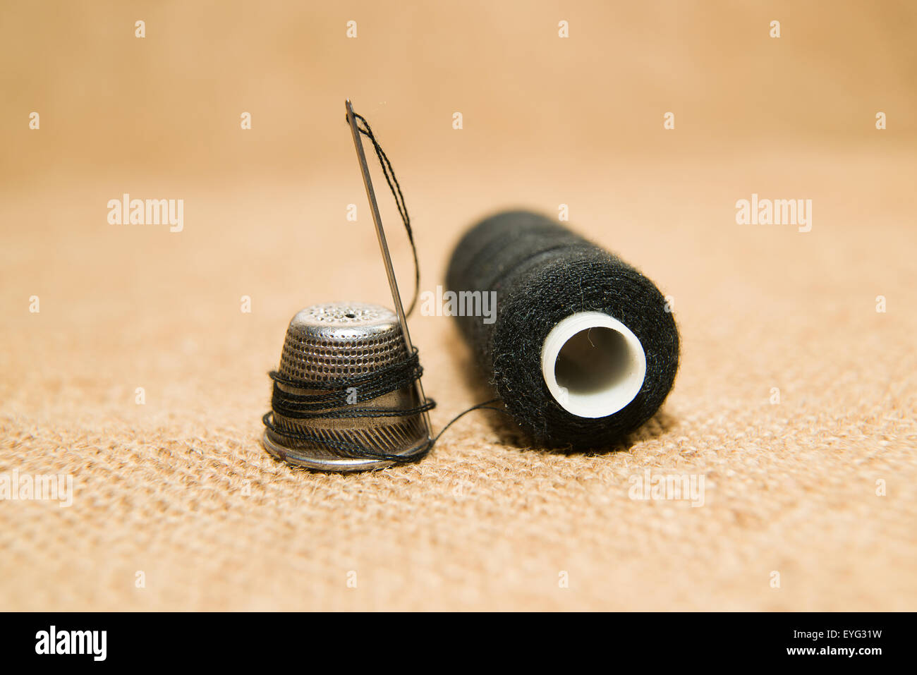 Sewing Needle, thimble and thread spool on the old cloth Stock Photo Alamy