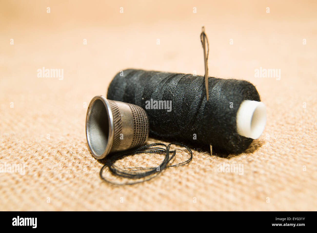 Sewing Needle, thimble and thread spool on the old cloth Stock Photo Alamy