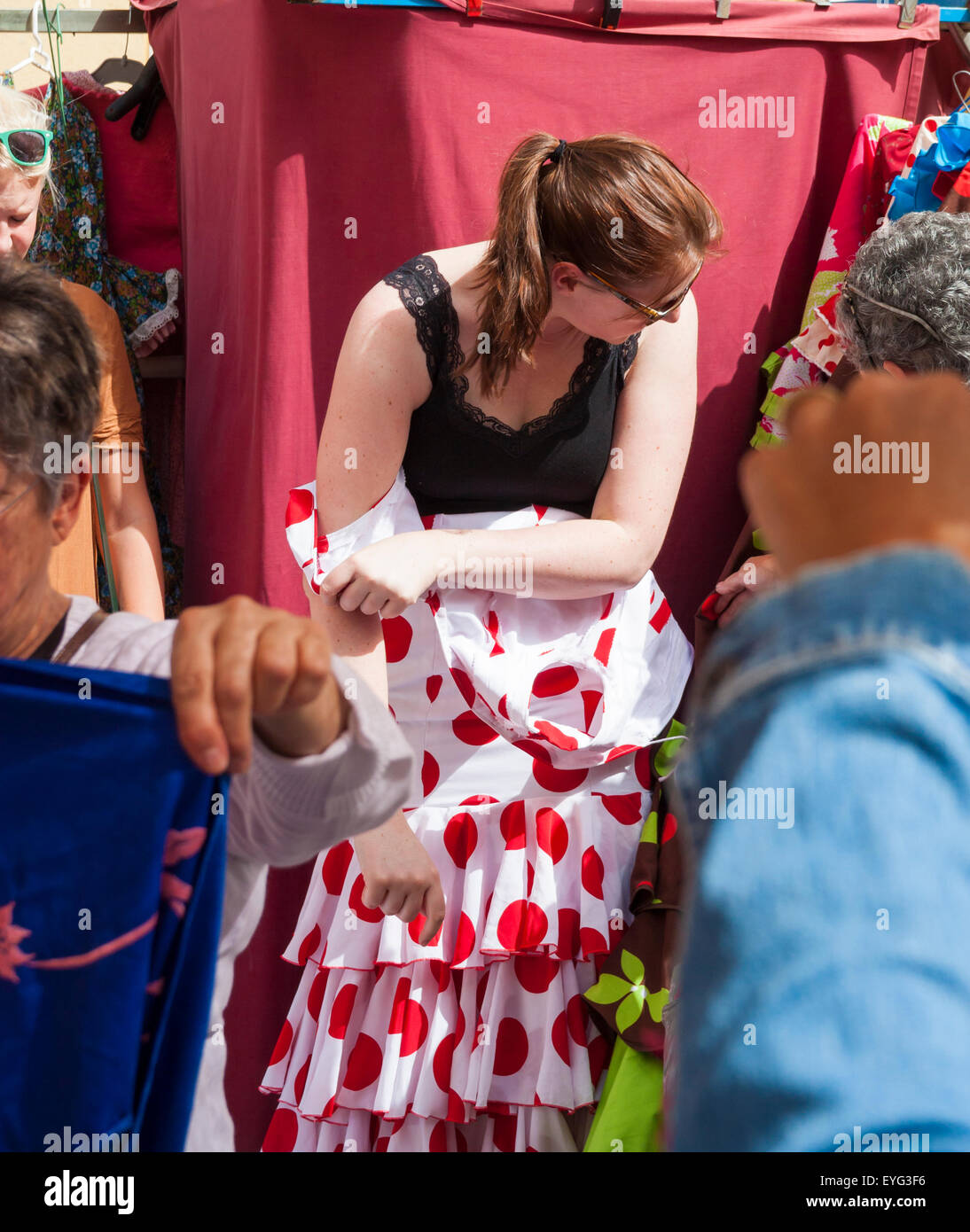 Tourist trying on secondhand Flamenco dress on famous street Flea market in Calle Feria in Seville, Spain Stock Photo