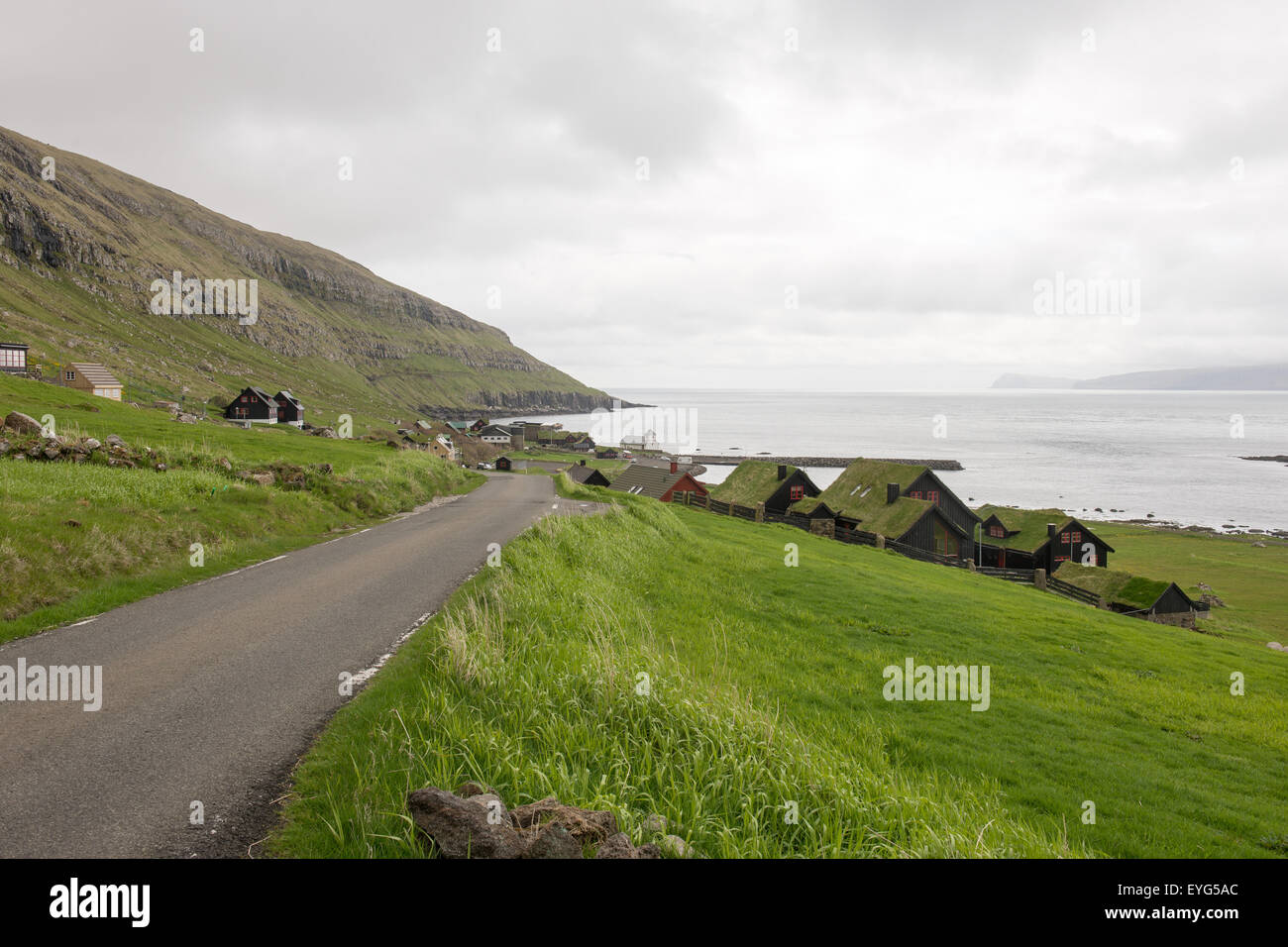 Kirkjubøur on the Faroe Islands with typical houses, church and road Stock Photo