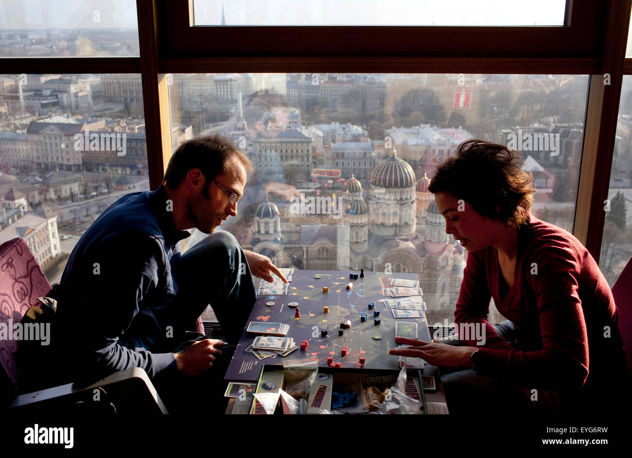 Visitors play a board game on the 26th floor of the Reval Hotel Skyline Bar, at sunset, Riga, Latvia. Stock Photo