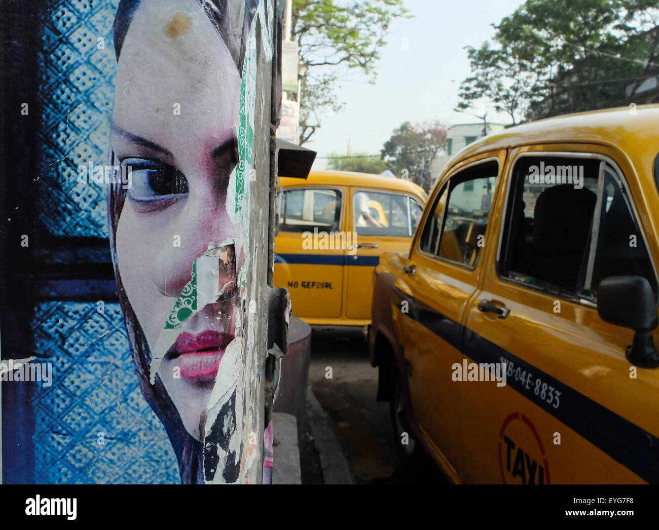 Torn poster & yellow taxis, Kolkata. Stock Photo