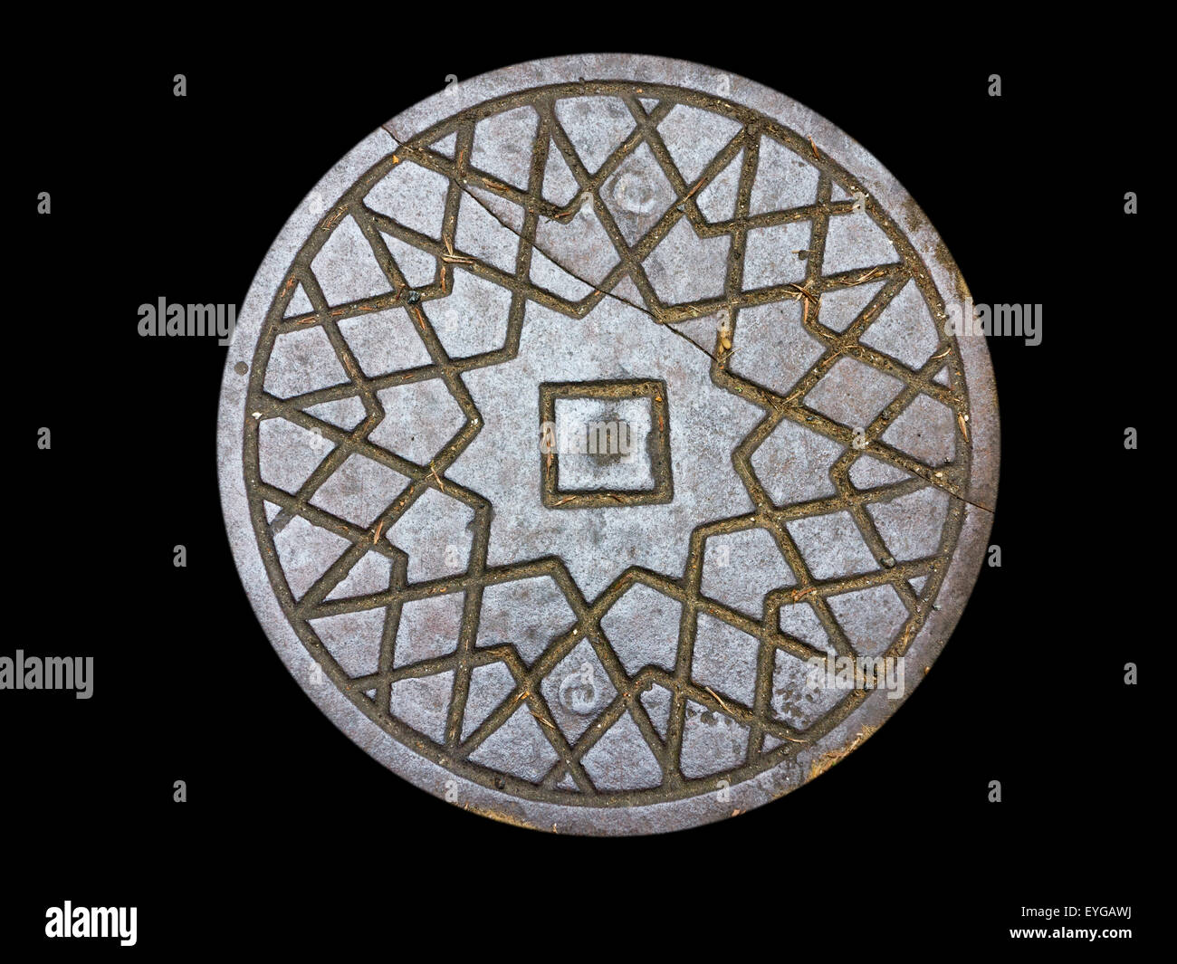 A single cast iron coal hole hatch against a black background Stock Photo