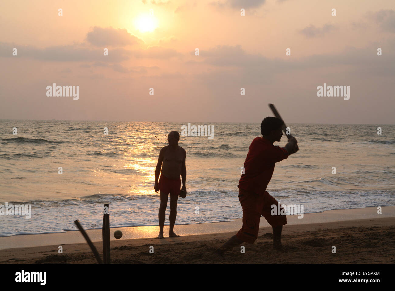 Playing cricket, the national sport of India, on Anjuna Beach at sunset, Goa State, India, Asia. Stock Photo