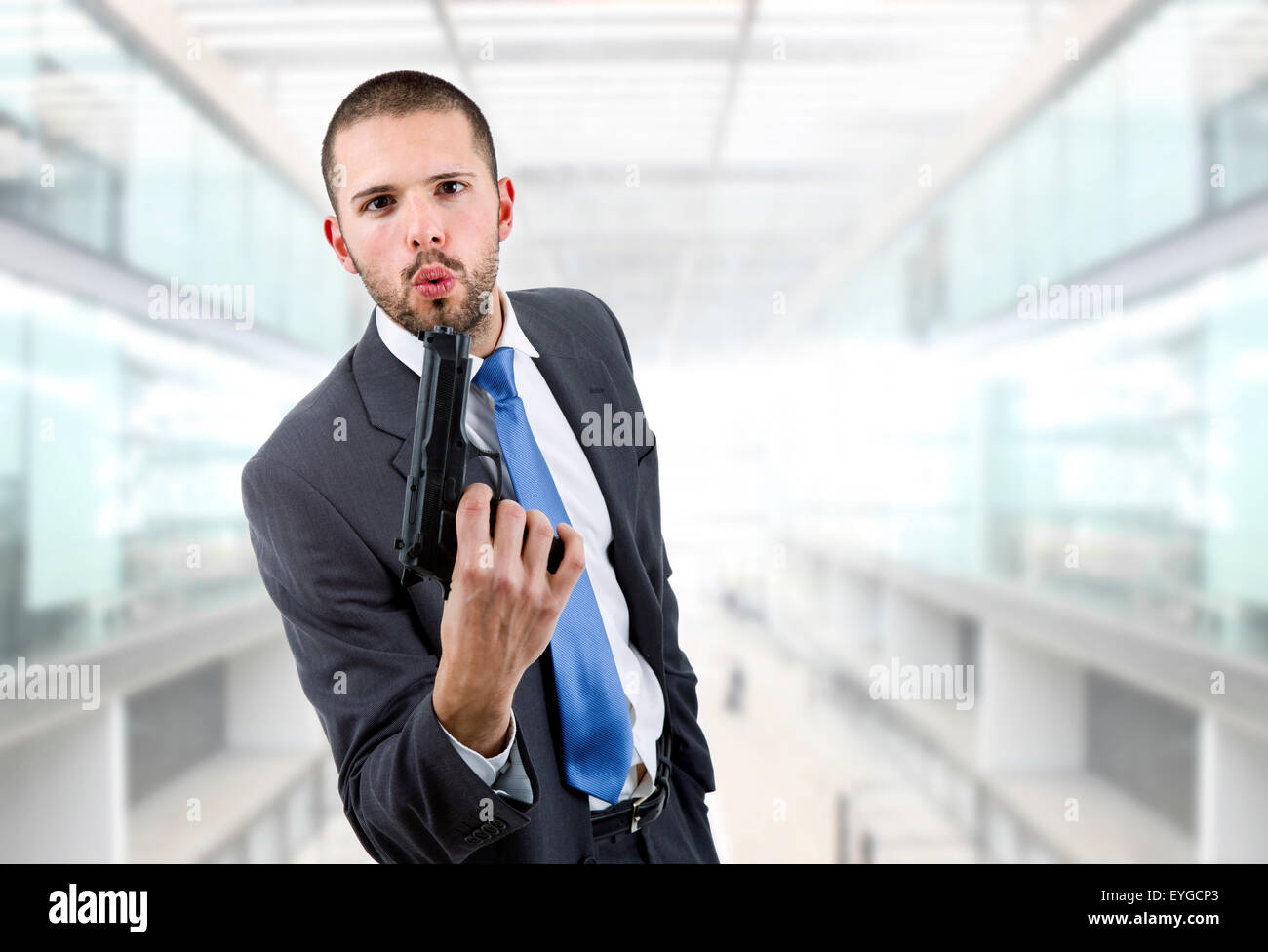 young businessman with a gun, at the office Stock Photo