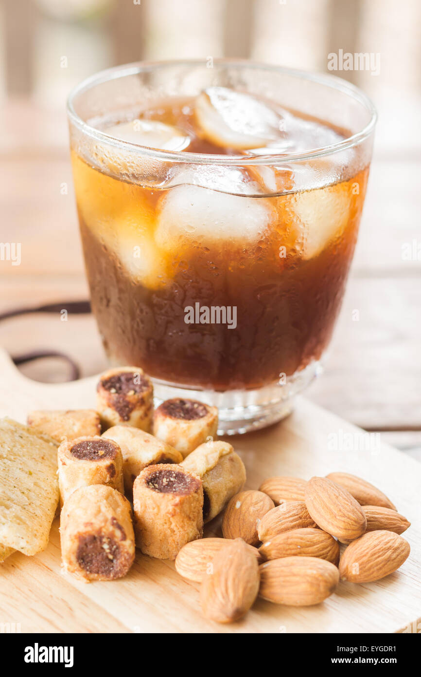 https://c8.alamy.com/comp/EYGDR1/glass-of-black-iced-coffee-with-some-snack-stock-photo-EYGDR1.jpg