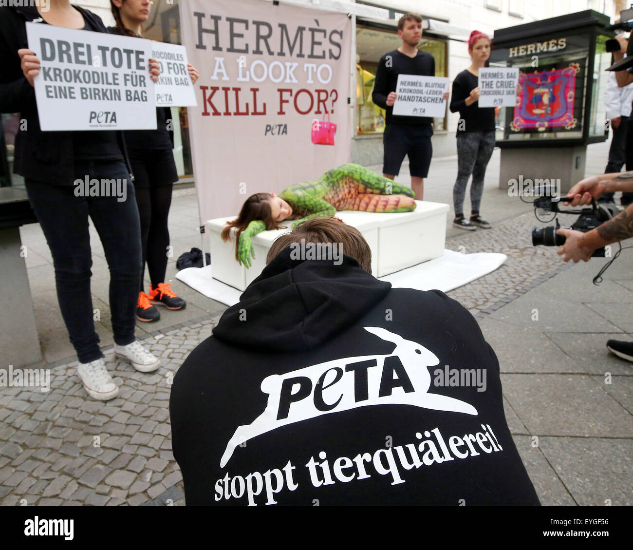 Berlin, Germany. 29th July, 2015. Members of the animal rights group Peta protest in front of a shop of the brand Hermes against the killing of crocodiles for luxury leather bags in Berlin, Germany, 29 July 2015. A model, painted with artificial crocodile skin, lies in a fake pool of blood on the Kurfuerstendamm in Berlin. Credit:  dpa picture alliance/Alamy Live News Stock Photo