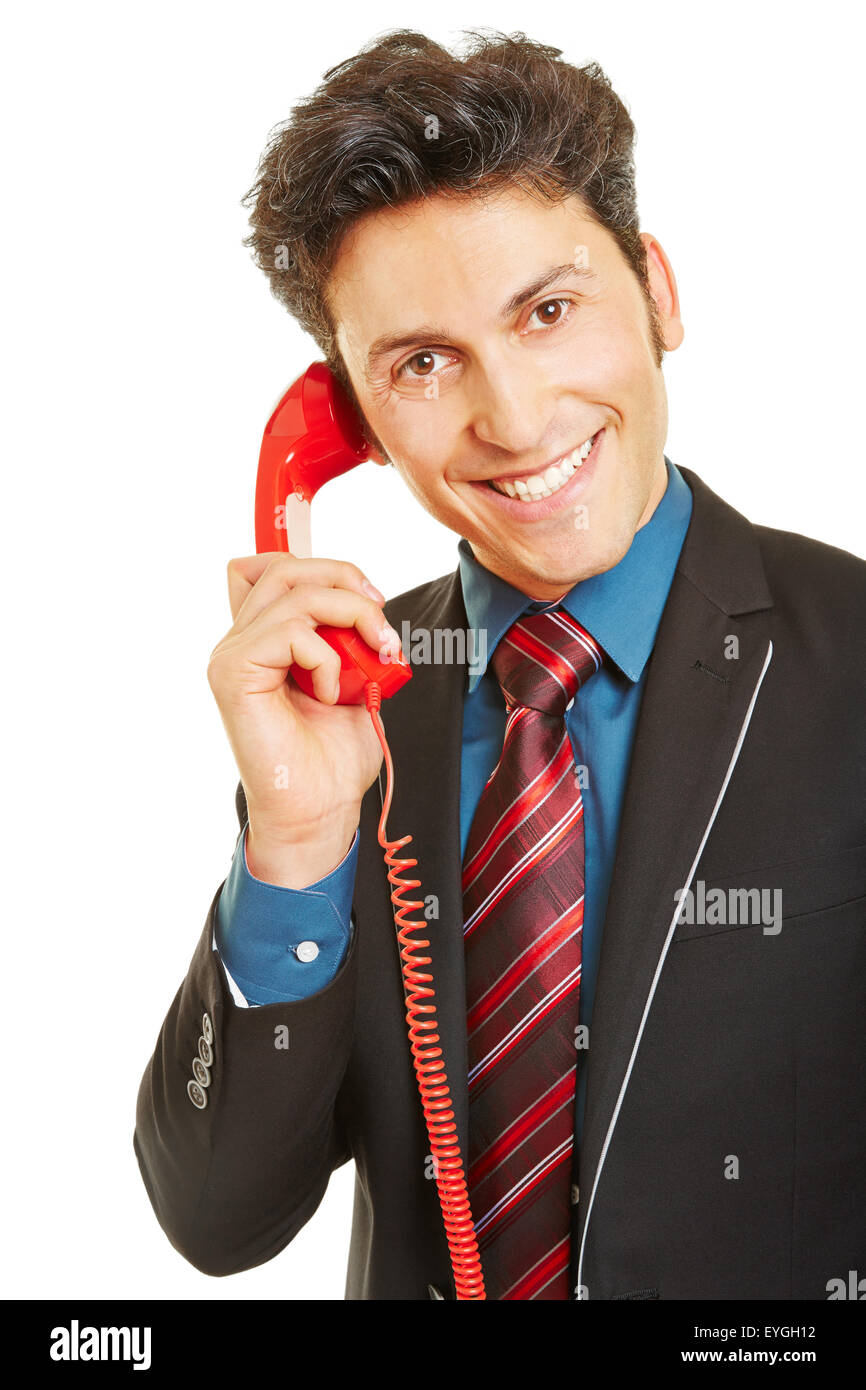 Smiling business man making phone call with a red telephone Stock Photo
