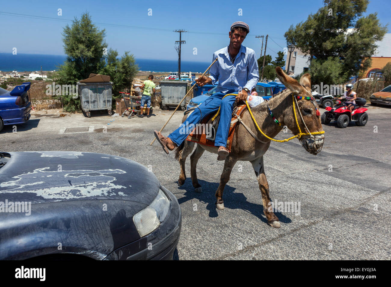 A rider on a donkey in Oia, Santorini, Greek Islands, Greece Man riding donkey Stock Photo