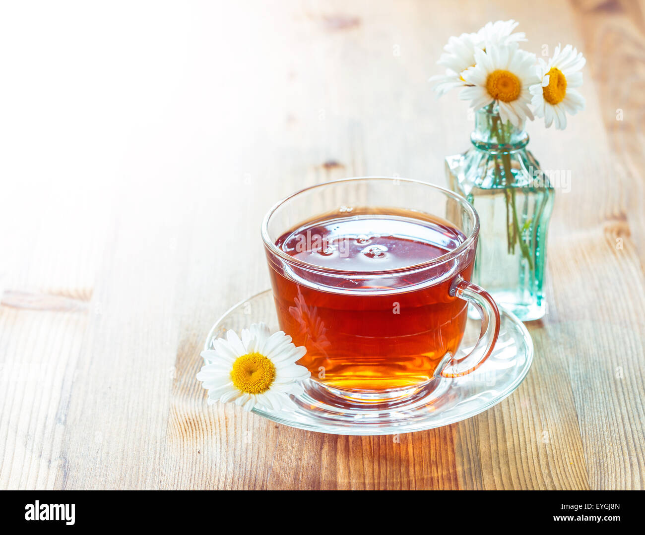 Glass cup of tea with chamomile flowers on rustic wooden background Stock Photo - Alamy