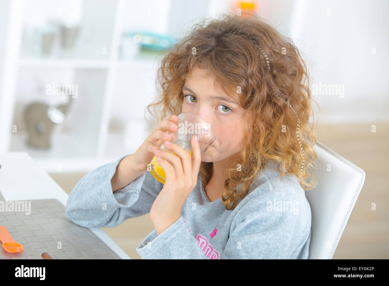 Little girl drinking orange juice Stock Photo - Alamy