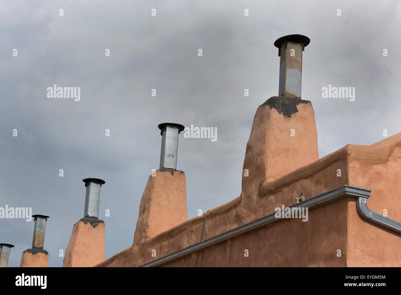 Row of chimneys on adobe building in Old Town district of Albuquerque, New Mexico.  Copy space in sky above architectural detail Stock Photo