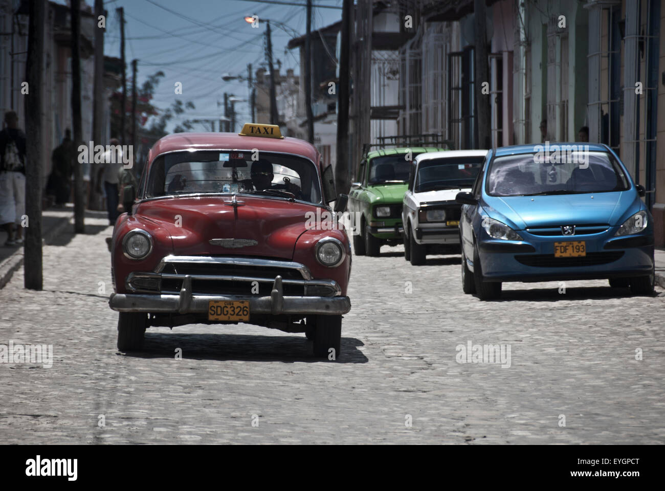 Vintage American car in Cuba with modern cars in contrast in Cienfuegos, Cuba Stock Photo