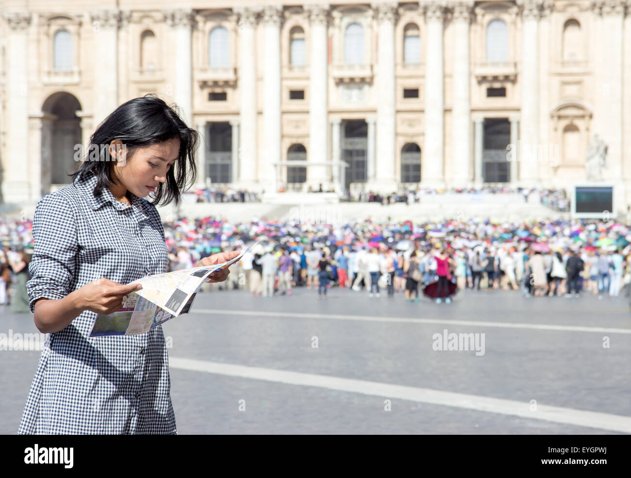 woman studying a city map at St. Peter's Basilica in Vatican Stock Photo