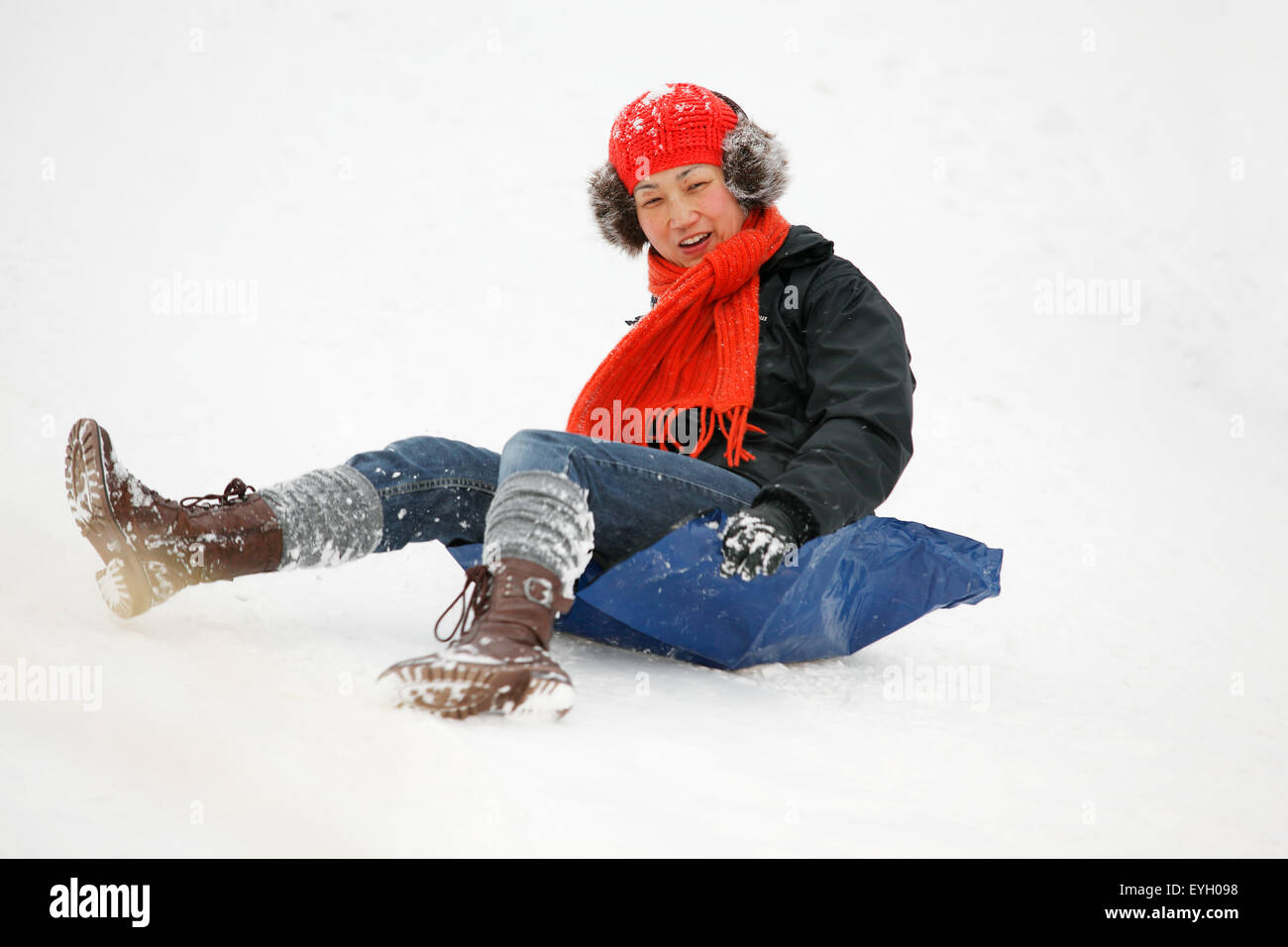 Women Using Plastic Sheet As Snow Sled; Greenwich Park, London, England, Uk Stock Photo