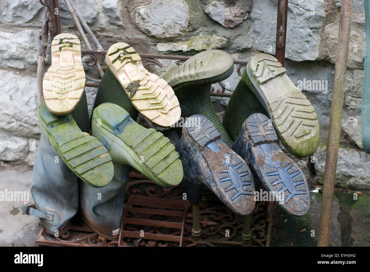 Wellington boots on a rack with stonewall in the background. Photo shows soles of the boots Stock Photo
