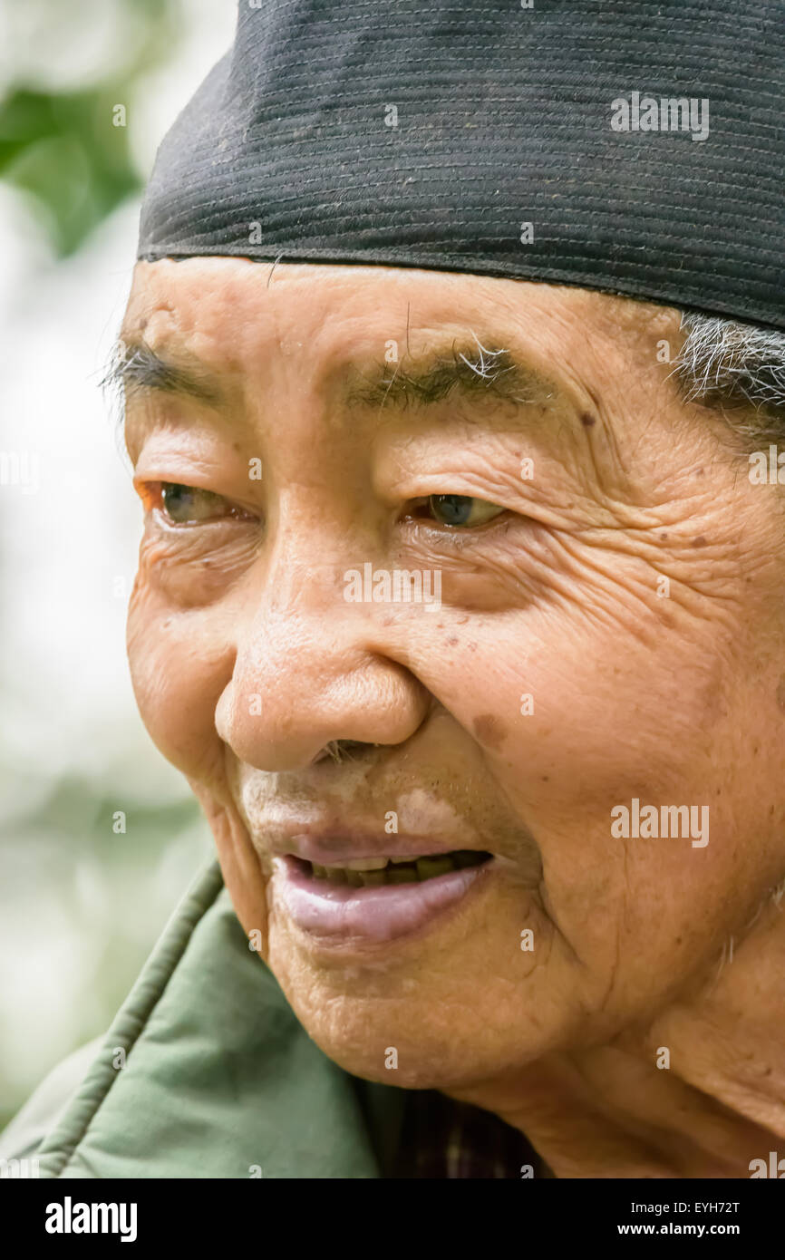 Portrait of an happy old nepali man mongoloid character with cap on head and gray hair and wrinkled face Stock Photo