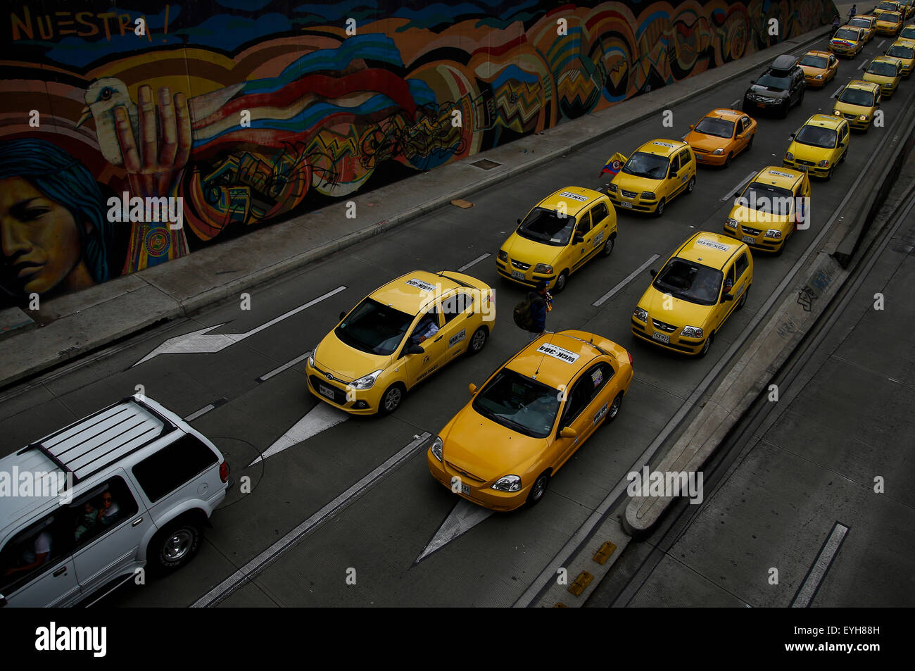 Bogota, Colombia. 29th July, 2015. Taxi drivers circulate in "turtle plan" during a protest against the transport service through the Uber app in Bogota, Colombia, on July 29, 2015. With the protest, taxi drivers demand the Government to forbid definitely providing taxi service to private vehicles, and to penalize taxis that provide the service through the Uber app, considered illegal some months ago. Credit:  Mauricio Alvarado/COLPRENSA/Xinhua/Alamy Live News Stock Photo