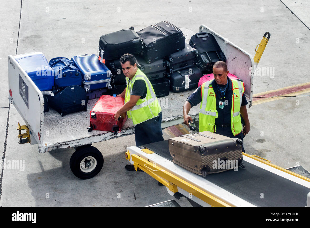 Miami Florida,International Airport,MIA,tarmac,apron,ground crew,baggage handlers,Hispanic Black African Africans,man men male,scanner,conveyor belt,l Stock Photo