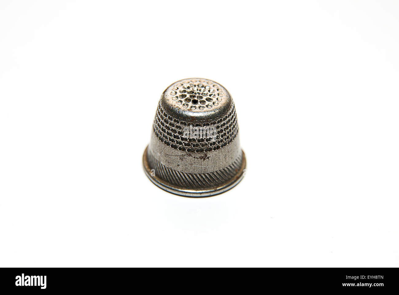 Vintage Iron thimble for hand embroidery on a white background Stock Photo