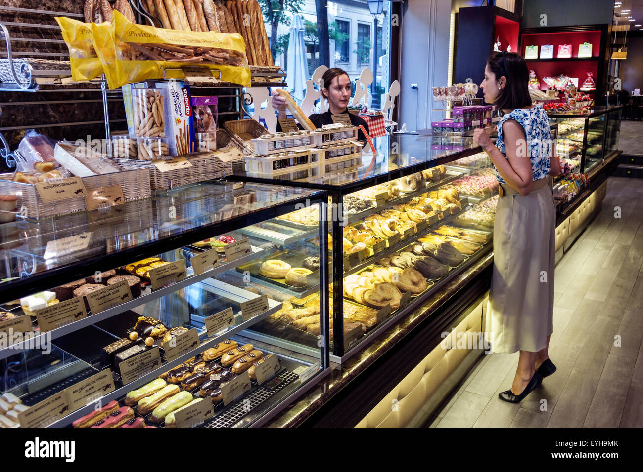 Madrid Spain,Vait,chain,bakery,cafeteria,pastry shop,display case,sweets,counter,breads,woman female women,patron,customer,standing,tiptoes,employee,j Stock Photo