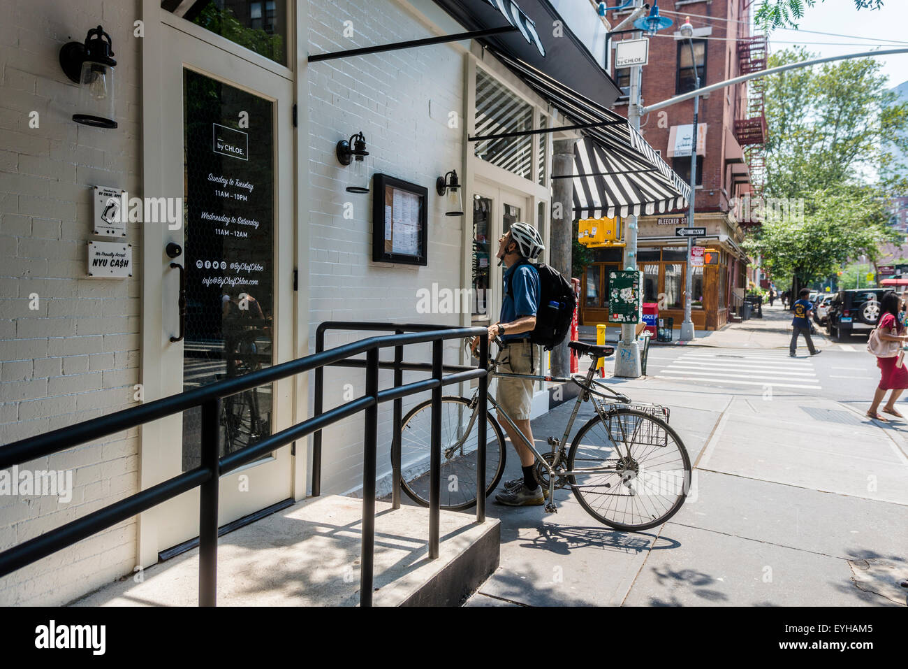 New York, NY 29 July 2015  A cyclist reads the menu outside By Chloe, a fruit and yogurt parlour, opens at the corner of Bleecker and MacDougal. The site previously housed Caffe Ciao, and Caffe Borgia Stock Photo