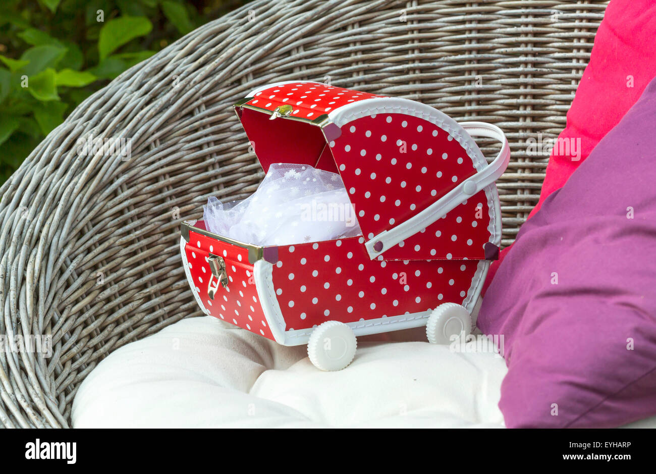 Little red doll buggy on a chair. Stock Photo