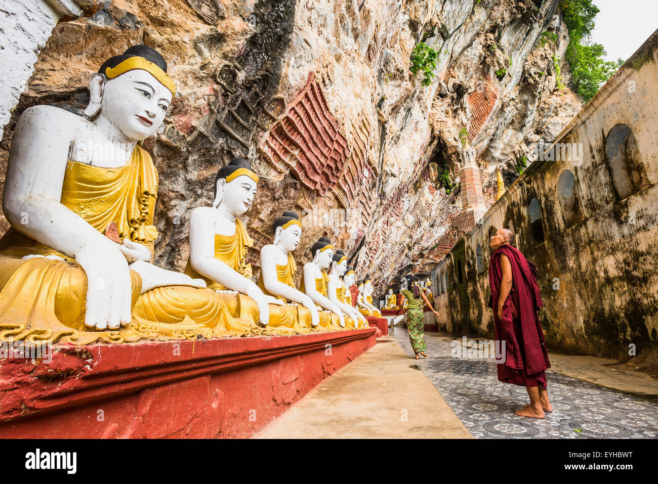 Monk looking at the seated Buddha statues, Kawgun Cave, Hpa-an, Karen or Kayin State, Myanmar Stock Photo
