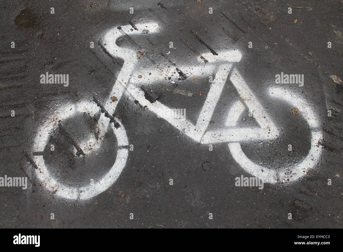 white painted sign of bicycle on black asphalt road mean way for bikes ...