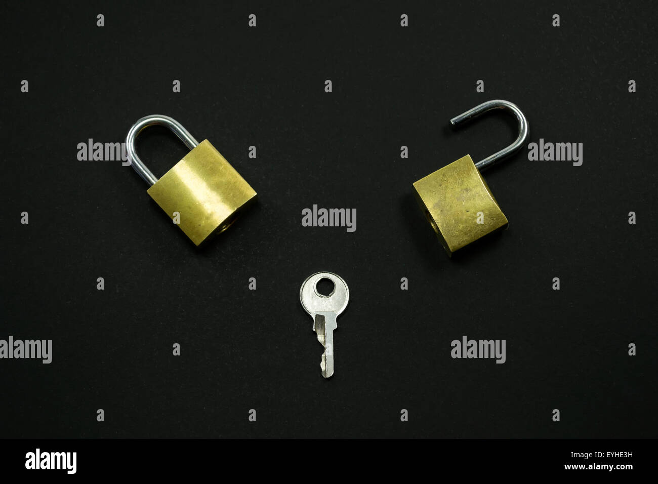 Two small locks and a key against a black background , conceptual image about problem solving process Stock Photo