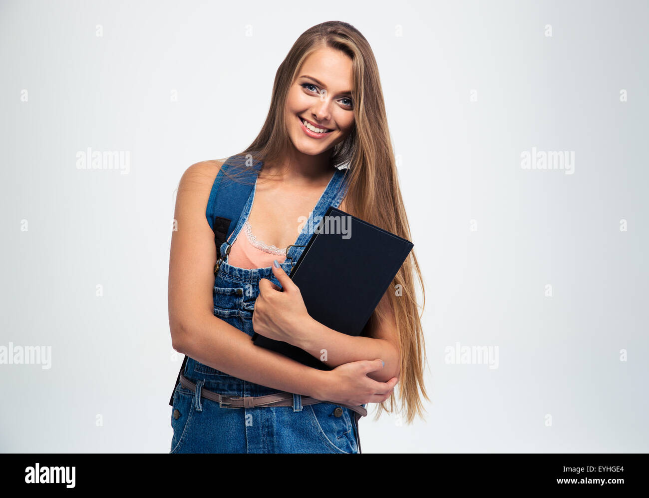 Portrait of a smiling young girl holding book isolated on a white ...