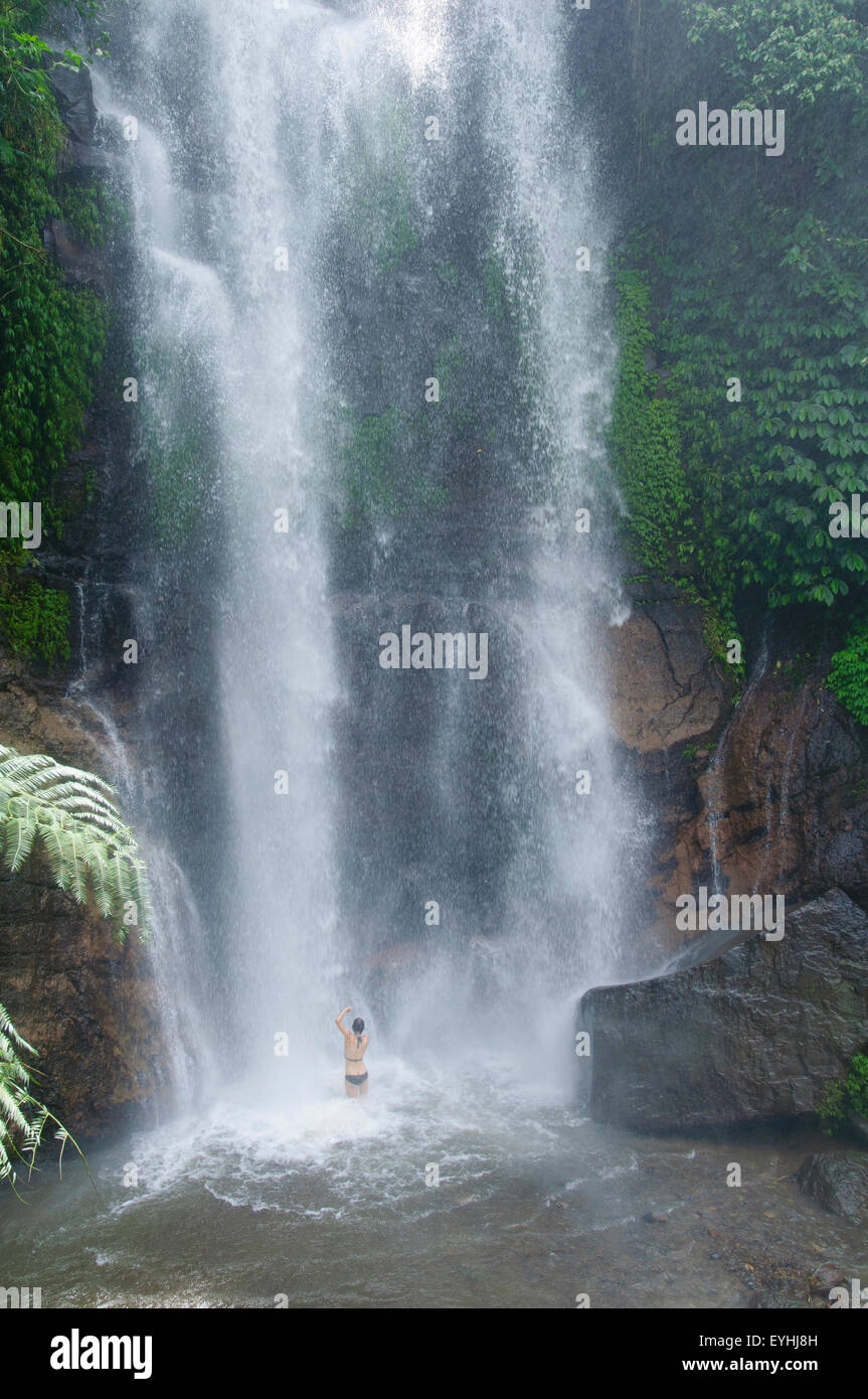 Girl bathes in Munduk waterfall, Bali, Indonesia, Pacific Ocean, No MR Stock Photo