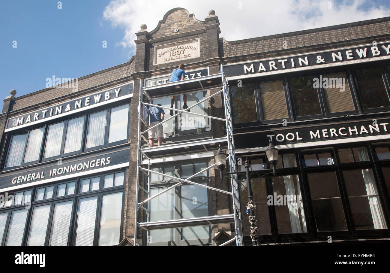 Painters working on scaffolding painting the Martin and Newby