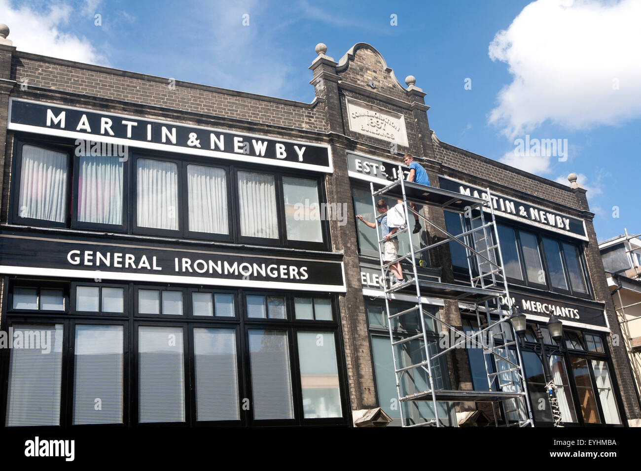 Painters working on scaffolding painting the Martin and Newby