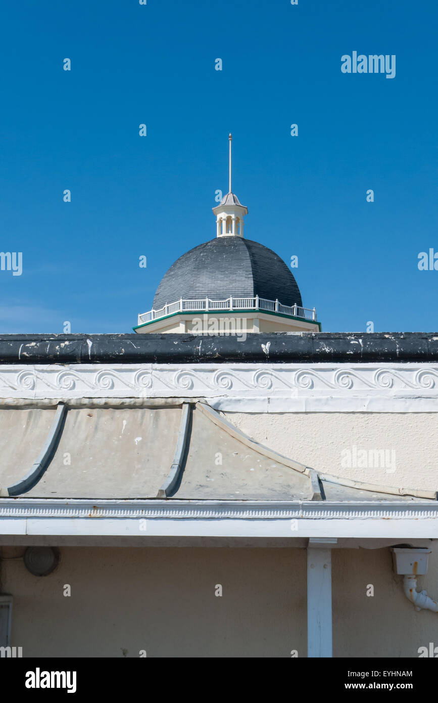 Hastings, England. Details of Victorian building; dome, cupola, flagpole, wave motif frieze and concave roof. Stock Photo