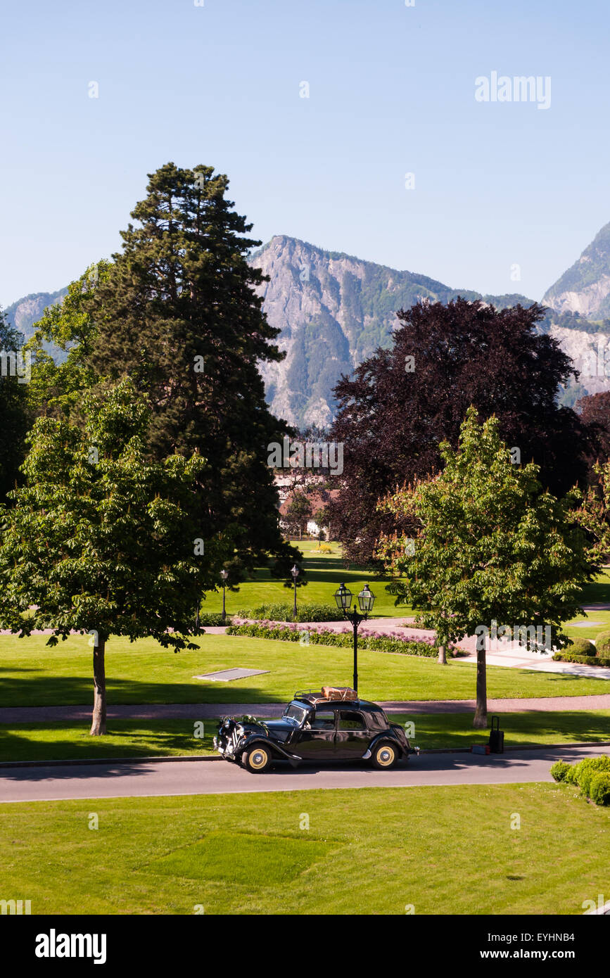 Switzerland. Vintage pre-war Citroen car with luggage rack in park by mountains. Stock Photo