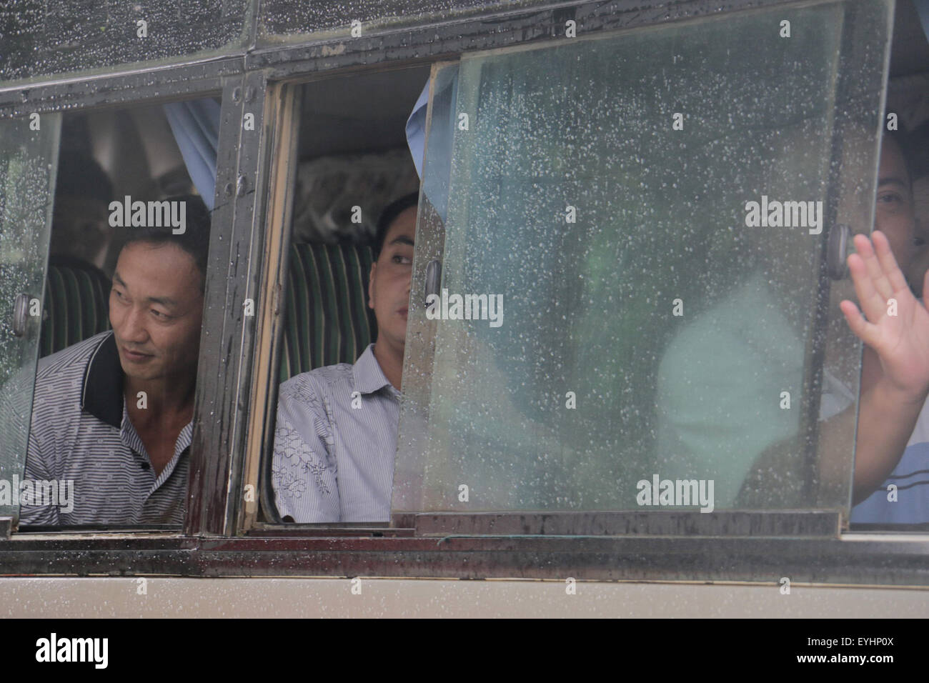 Myitkyina. 30th July, 2015. Chinese loggers look out from the bus window after being freed from Myitgyina Jail, July 30, 2015. The Myanmar government on Thursday granted an amnesty to 6,966 prisoners including 155 detained Chinese loggers. © Myitkyinabrang/Xinhua/Alamy Live News Stock Photo