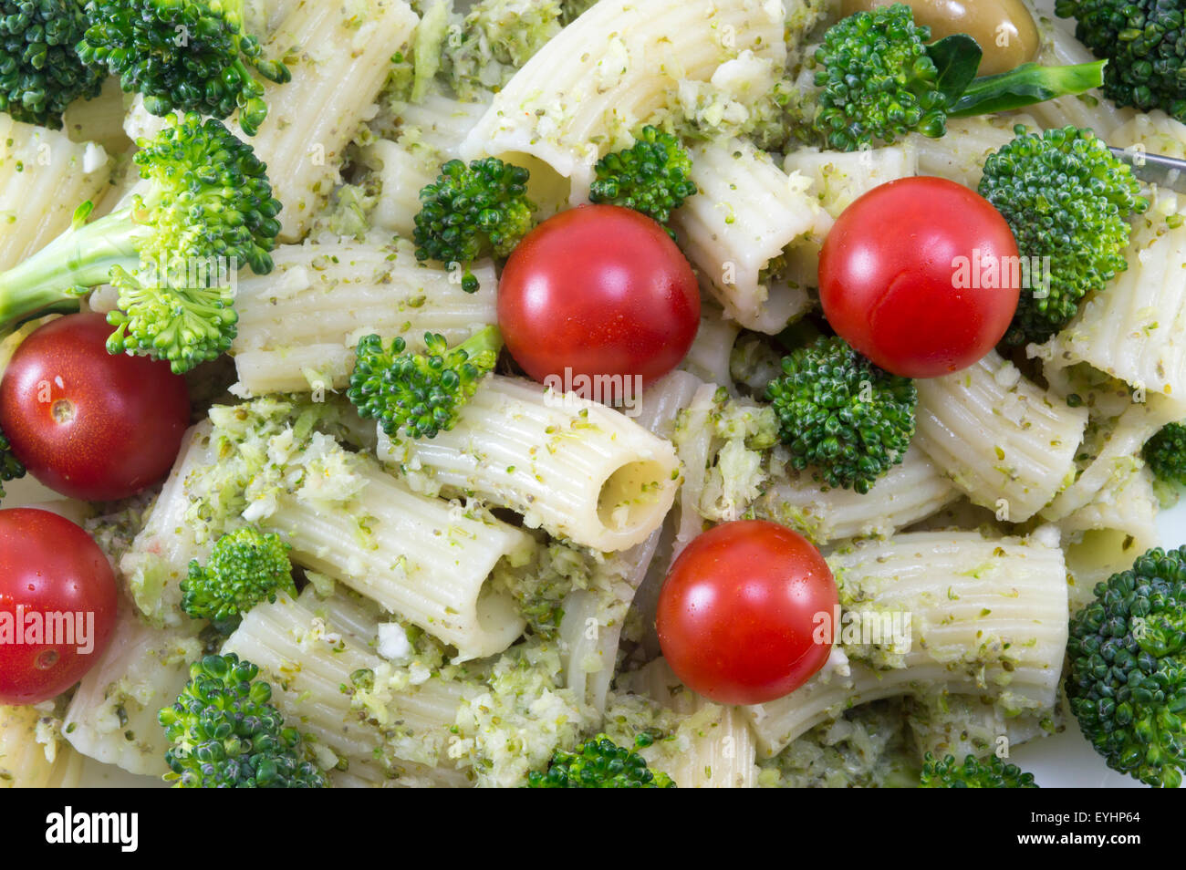 Pasta with broccoli and whole cherry tomatoes served close-up Stock Photo