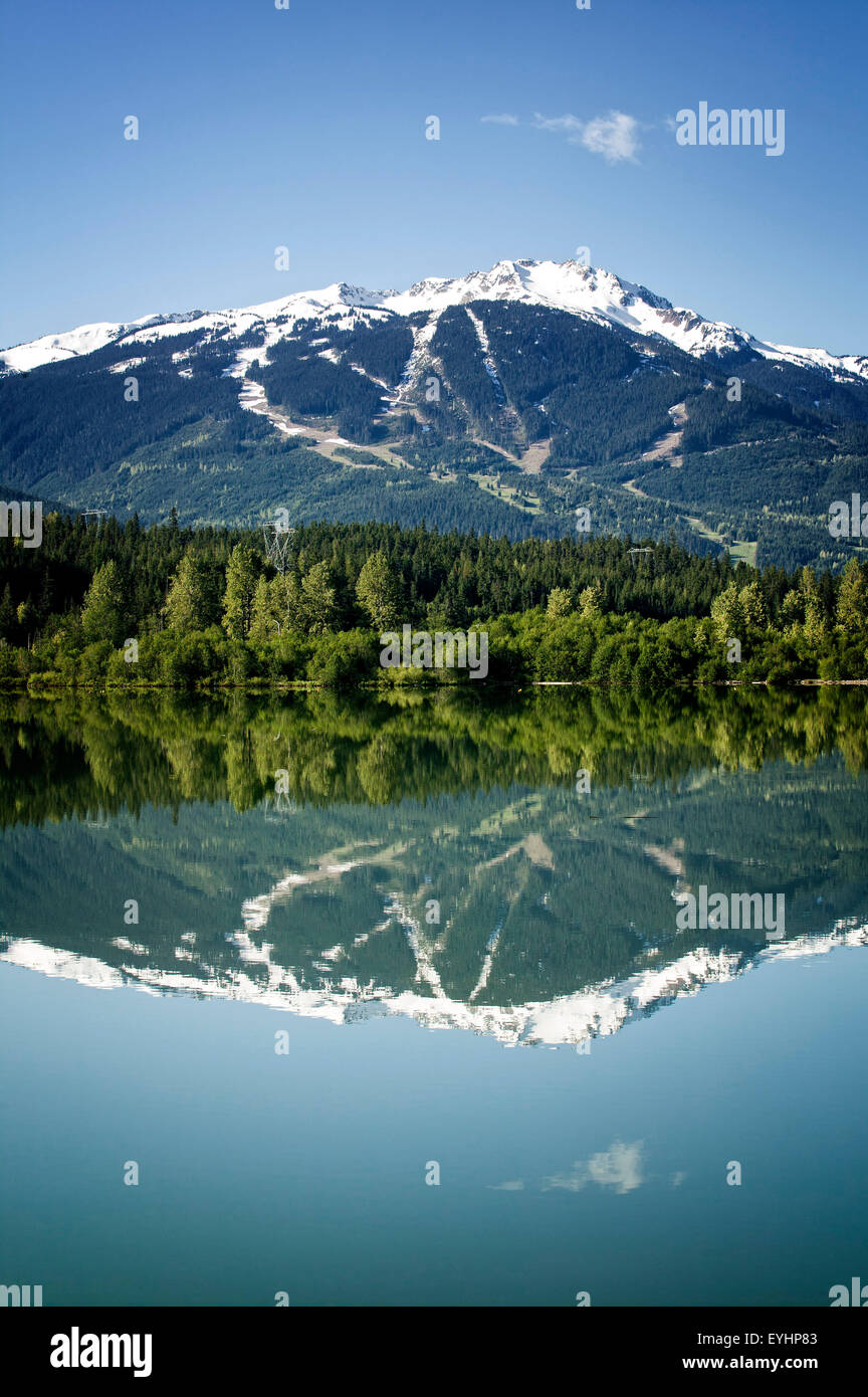 The slopes of Whistler Blackcomb reflect in Green Lake, British Columbia Stock Photo