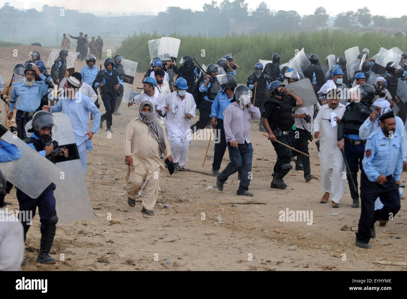 Islamabad. 30th July, 2015. Riot police arrive during an operation against illegal houses at a slum on the outskirts of Islamabad, capital of Pakistan on July 30, 2015. At least 18 people including six policemen were injured as slum-dwellers protested against the Capital Development Authority on Thursday. The city administration launched an operation to bulldoze houses in an illegal settlement in Islamabad, local media reported. © Ahmad Kamal/Xinhua/Alamy Live News Stock Photo