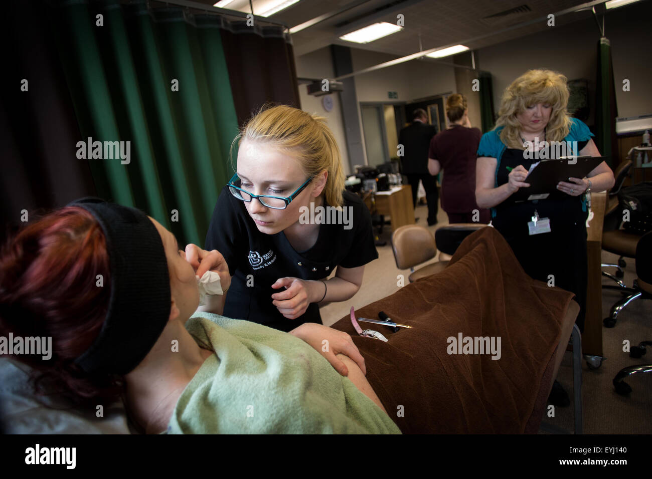 A beauty student is marked by a teacher at Bolton College , UK Stock Photo