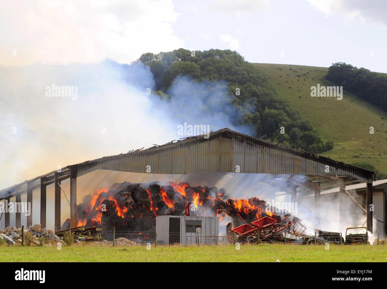 Plumpton, East Sussex, UK..30 July 2015..Fire Service contain Fire in new hay and straw storage barn at Plumpton Agricultural College. Intense heat is being generated. Farm Manager spoke highly of the Fire Service who could be on scene for some days. Any increse in the wind could cause problems Stock Photo