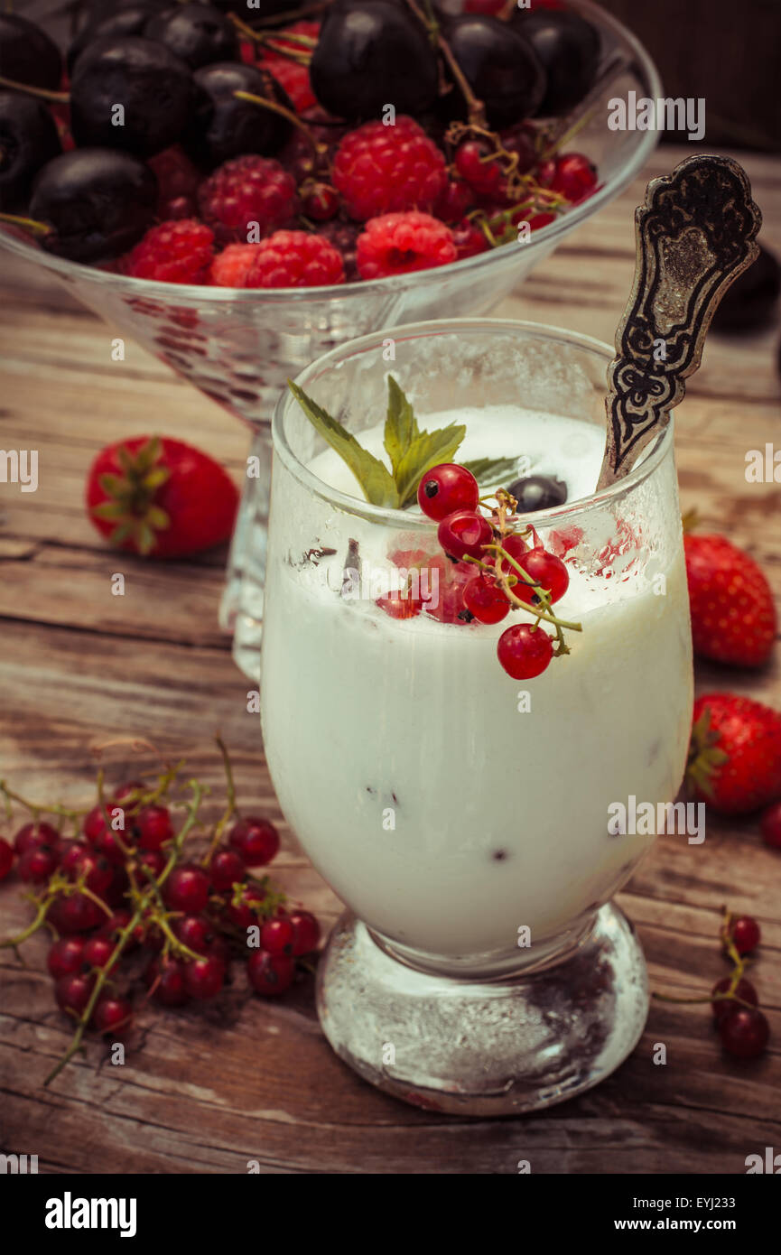 sweet dessert of ice cream per glass and fresh berries, cherries,currants,strawberries.Photo tinted. Stock Photo