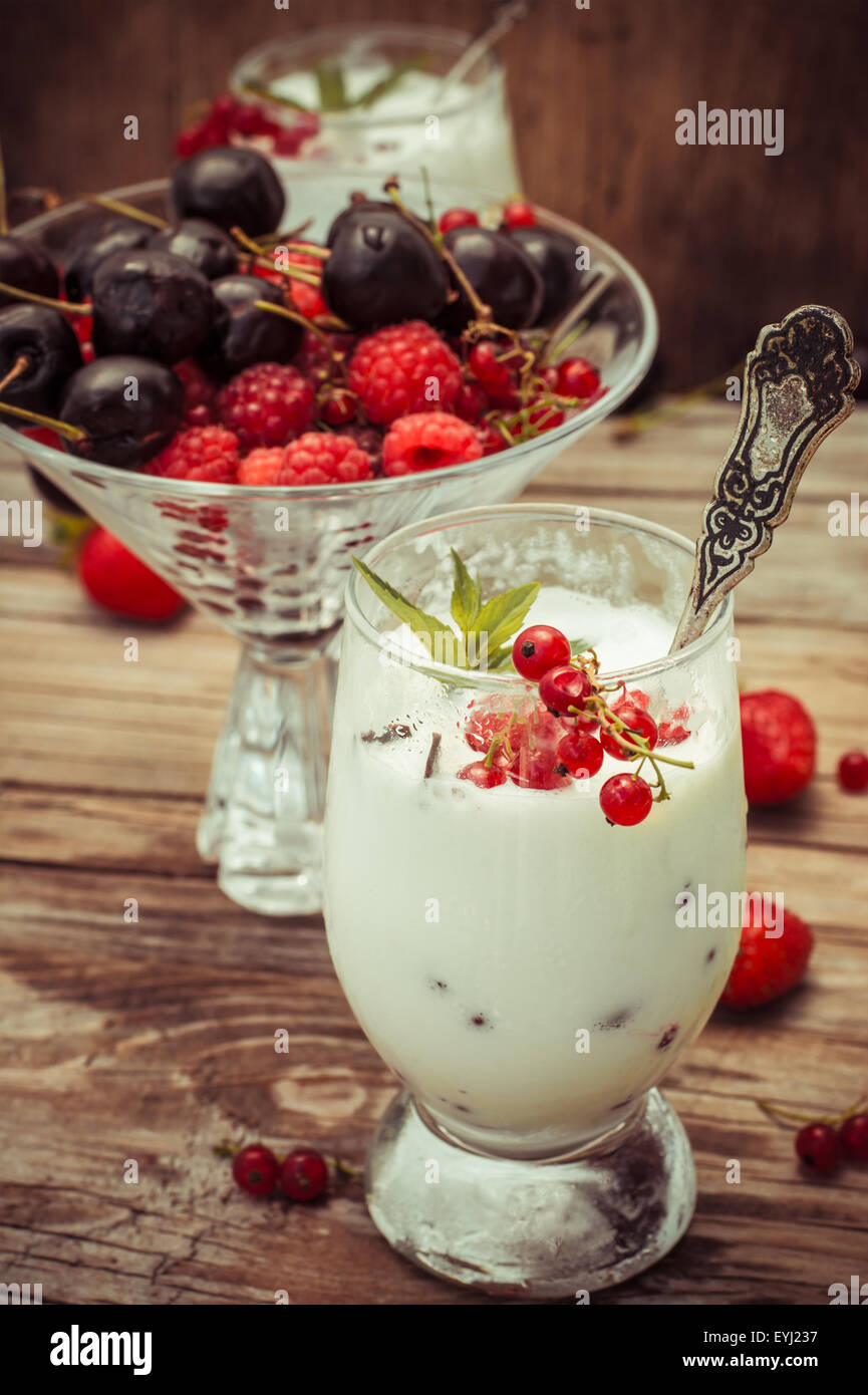 sweet dessert of ice cream per glass and fresh berries, cherries,currants,strawberries.Photo tinted. Stock Photo