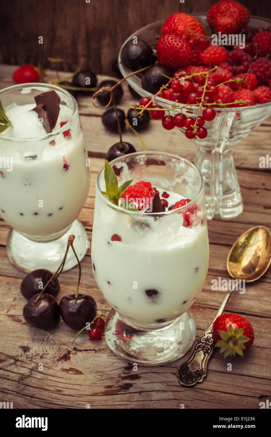 sweet dessert of ice cream per glass and fresh berries, cherries,currants,strawberries.Photo tinted. Stock Photo